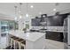 Modern kitchen featuring stainless steel appliances, a center island, pendant lighting, and dark cabinets at 100 Verde Way, Debary, FL 32713