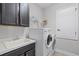 Functional laundry room with washer, dryer, utility sink, and storage shelves at 100 Verde Way, Debary, FL 32713