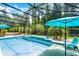The pool is surrounded by a screened enclosure, tropical plants and outdoor furniture at 100 Verde Way, Debary, FL 32713