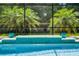 A screened pool with a waterfall feature, tropical plants and blue planters at 100 Verde Way, Debary, FL 32713