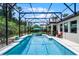 A screened pool with a waterfall feature, outdoor furniture and a tropical landscape at 100 Verde Way, Debary, FL 32713