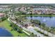 Aerial view of a community entrance with lush landscaping, palm trees, a pond, and a fountain feature, showcasing the entry at 10120 Sunnifa Aly, Orlando, FL 32832