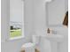 Clean and bright powder room with a pedestal sink, toilet, and window with neighborhood view at 10120 Sunnifa Aly, Orlando, FL 32832