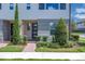 Charming front entrance with modern door, brick pathway, and professionally landscaped bushes and trees, enhancing the home's curb appeal at 10120 Sunnifa Aly, Orlando, FL 32832