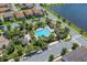 Aerial view of a community pool with palm trees, lounge chairs, cabanas, and a lake in the background at 10120 Sunnifa Aly, Orlando, FL 32832