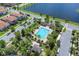 Community pool surrounded by palm trees, featuring lounge chairs, cabanas, and a scenic lake in the background at 10120 Sunnifa Aly, Orlando, FL 32832