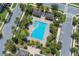 Aerial view of a community pool, palm trees, lounge chairs, and surrounding buildings, showcasing recreational amenities at 10120 Sunnifa Aly, Orlando, FL 32832