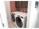 Clean laundry room equipped with two large washing machines and overhead cabinets at 14146 Jomatt Loop, Winter Garden, FL 34787