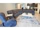 Open concept living room with a large gray sectional, recliner, light-colored floors and a modern rug at 14146 Jomatt Loop, Winter Garden, FL 34787
