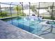 Inviting screened-in pool area with blue tiled accents, a spa, and a spacious deck for relaxation at 14146 Jomatt Loop, Winter Garden, FL 34787