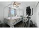 Bright bedroom features a four poster bed, dark flooring, and an elliptical machine at 16262 Firedragon Dr, Winter Garden, FL 34787