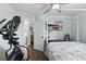Bright bedroom features a four poster bed, dark flooring, and an elliptical machine at 16262 Firedragon Dr, Winter Garden, FL 34787