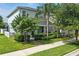 Exterior side view of home featuring beautiful landscaping, lawn, and a lovely blooming tree at 16262 Firedragon Dr, Winter Garden, FL 34787
