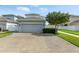 Exterior view of the garage showcasing the driveway, landscaping, and the home's facade at 16262 Firedragon Dr, Winter Garden, FL 34787