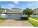Garage exterior featuring a gray door, brick driveway, and well-maintained landscaping at 16262 Firedragon Dr, Winter Garden, FL 34787