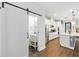 Modern kitchen with stainless steel appliances, white cabinets, and a sliding barn door to powder room at 16262 Firedragon Dr, Winter Garden, FL 34787