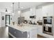 Modern kitchen with white cabinets, stainless steel appliances, a large island, and pendant lighting at 16262 Firedragon Dr, Winter Garden, FL 34787