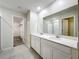 Elegant Primary bathroom features double sink vanity, a walk-in closet, and tile floors at 16436 Fernridge St, Clermont, FL 34714