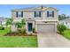 Charming two-story home with landscaped yard, beautiful lawn and a two car garage at 16436 Fernridge St, Clermont, FL 34714