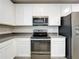 Kitchen with white cabinets, stainless steel appliances and grey countertops at 16436 Fernridge St, Clermont, FL 34714