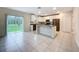 Open kitchen with white cabinets, stainless steel appliances, island, and sliding glass doors at 16436 Fernridge St, Clermont, FL 34714