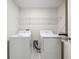 Functional laundry room with modern washer, dryer, and convenient overhead shelving at 16436 Fernridge St, Clermont, FL 34714