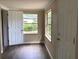 Bright bedroom features wood-look flooring and view of backyard greenery from two windows at 200 W Doane Ave, Eustis, FL 32726