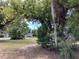 Scenic front yard view with mature trees, landscaping, and a glimpse of the charming neighborhood at 200 W Doane Ave, Eustis, FL 32726