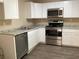 Well-lit kitchen with stainless steel appliances, white cabinets, and granite countertops at 200 W Doane Ave, Eustis, FL 32726
