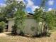 Back exterior view of the home surrounded by mature trees and lush greenery providing additional privacy at 200 W Doane Ave, Eustis, FL 32726