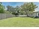 Expansive backyard featuring lush green grass, mature trees, and a well-maintained fence at 2430 Westwood Dr, Longwood, FL 32779
