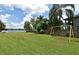 Lush backyard with mature trees, a yellow swing set and lake views at 2430 Westwood Dr, Longwood, FL 32779