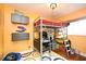 bedroom with orange walls, hardwood floors and a loft bed with a desk underneath at 2430 Westwood Dr, Longwood, FL 32779