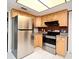 Modern kitchen with stainless steel fridge and oven plus light wood cabinets and tiled floors at 2430 Westwood Dr, Longwood, FL 32779