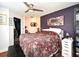 Comfortable bedroom with floral bedding, ceiling fan, and artistic decor at 2430 Westwood Dr, Longwood, FL 32779