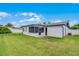 Exterior view of the home highlighting the screened-in porch and a well-maintained, grassy backyard at 2932 Carriage Dr, South Daytona, FL 32119