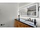 Modern bathroom features a wood vanity cabinet, black countertop, lighted mirror, and a tiled walk-in shower with glass door at 2932 Carriage Dr, South Daytona, FL 32119
