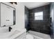 Sleek bathroom featuring a black tiled shower over tub, a black framed mirror, and a modern vanity with black fixtures at 2932 Carriage Dr, South Daytona, FL 32119
