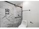 Modern tiled bathroom features a glass-enclosed walk-in shower with black fixtures, toilet, and a decorative niche at 2932 Carriage Dr, South Daytona, FL 32119