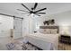 Bedroom with a tufted headboard, neutral tones, barn door to the bathroom, and a modern ceiling fan at 2932 Carriage Dr, South Daytona, FL 32119