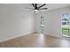 This airy bedroom has wood floors, two windows, a modern ceiling fan, and ample natural light at 2932 Carriage Dr, South Daytona, FL 32119