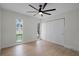 This bright bedroom features wood floors, two windows, a ceiling fan, and a closet with sliding doors at 2932 Carriage Dr, South Daytona, FL 32119