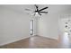 Neutral bedroom featuring wood flooring, a ceiling fan, a bright window, and a doorway to the hallway at 2932 Carriage Dr, South Daytona, FL 32119