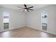 Bright bedroom features two windows, wood flooring, a modern ceiling fan, and neutral walls at 2932 Carriage Dr, South Daytona, FL 32119