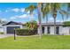 Charming single-story home featuring a well-manicured lawn and mature landscaping with palm trees at 2932 Carriage Dr, South Daytona, FL 32119
