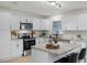 Bright kitchen with stainless steel appliances, granite countertops, a center island, and modern fixtures at 2932 Carriage Dr, South Daytona, FL 32119