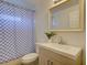 Clean bathroom with modern vanity, framed mirror, and a blue checkered shower curtain at 5123 Pineland Ave, Port Orange, FL 32127