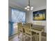Bright dining area featuring a rustic wood table set, chandelier, and decorative window treatments at 5123 Pineland Ave, Port Orange, FL 32127
