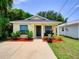 Charming yellow home with inviting front yard and vibrant landscaping under a clear blue sky at 5123 Pineland Ave, Port Orange, FL 32127