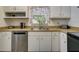 Well-lit kitchen featuring white cabinets, stainless steel appliances, and a functional layout at 5123 Pineland Ave, Port Orange, FL 32127
